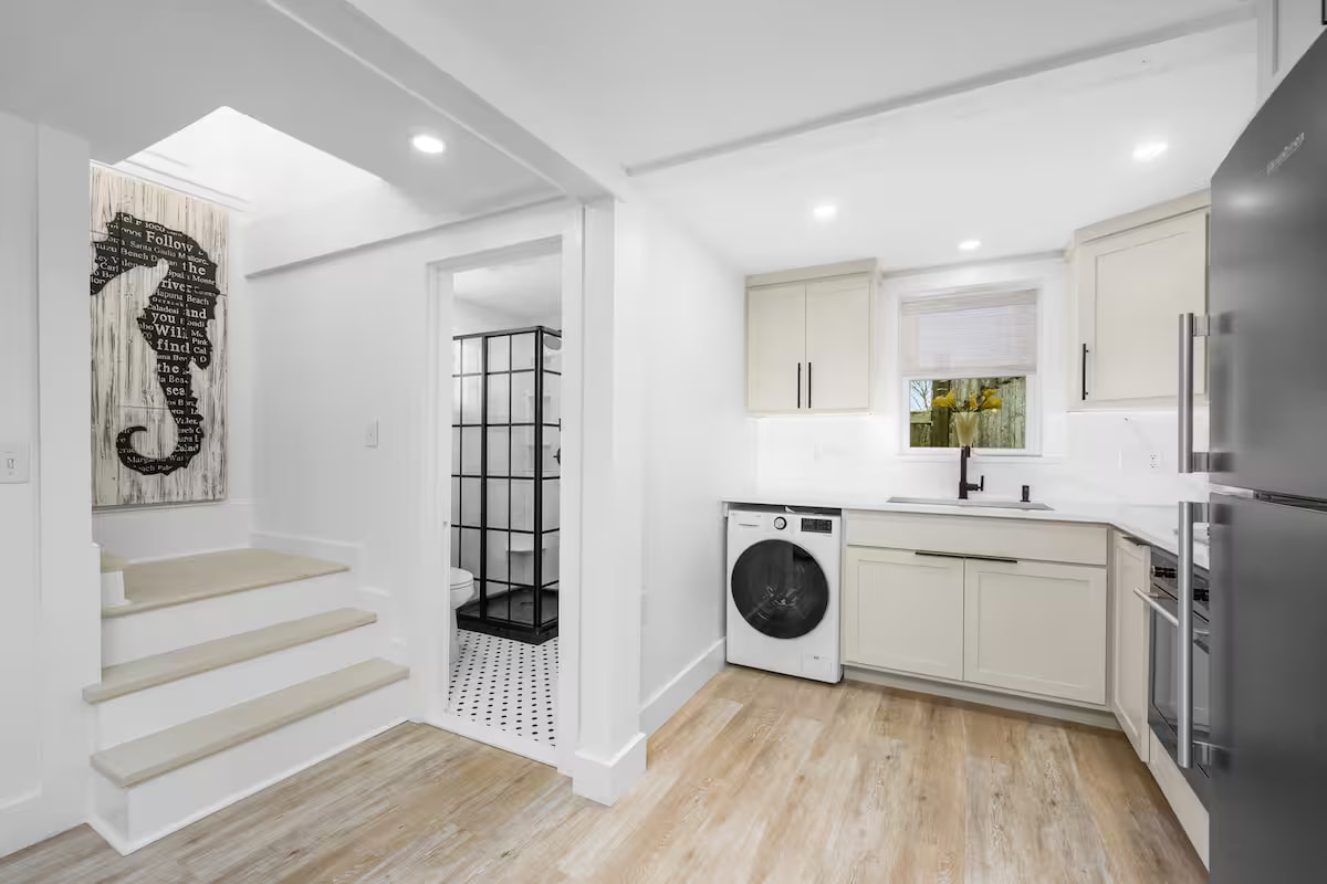 Cape Coddage kitchen with bathroom and stairs in background