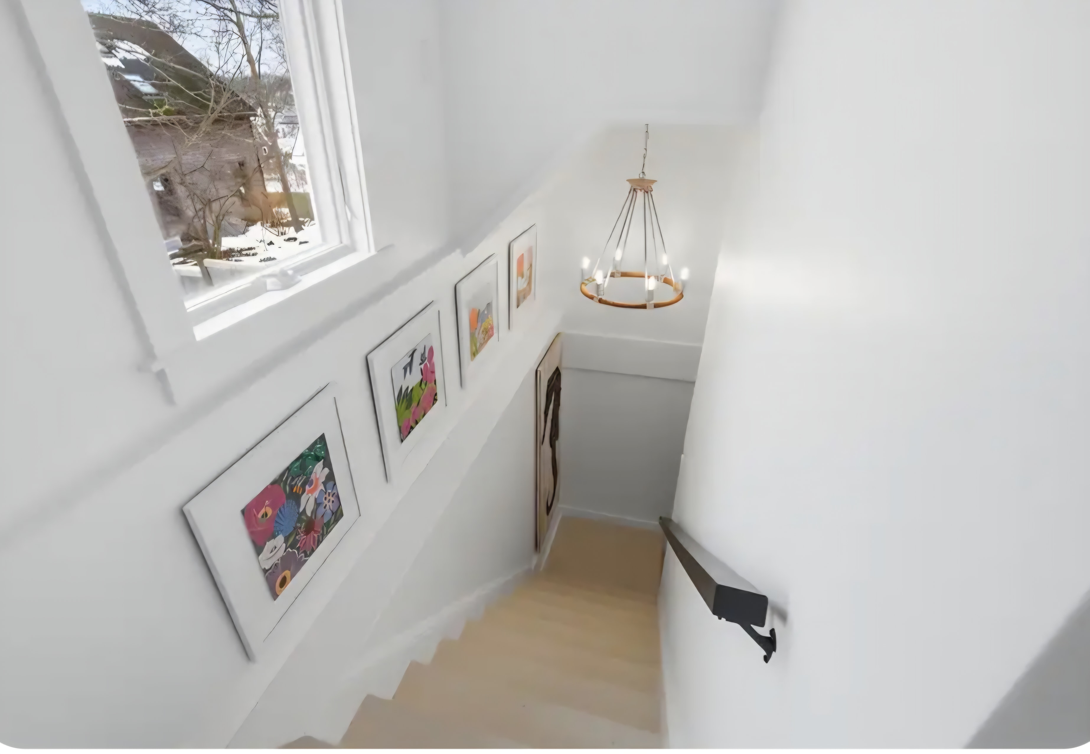 Cape Coddage staircase with gallery wall and rattan chandelier